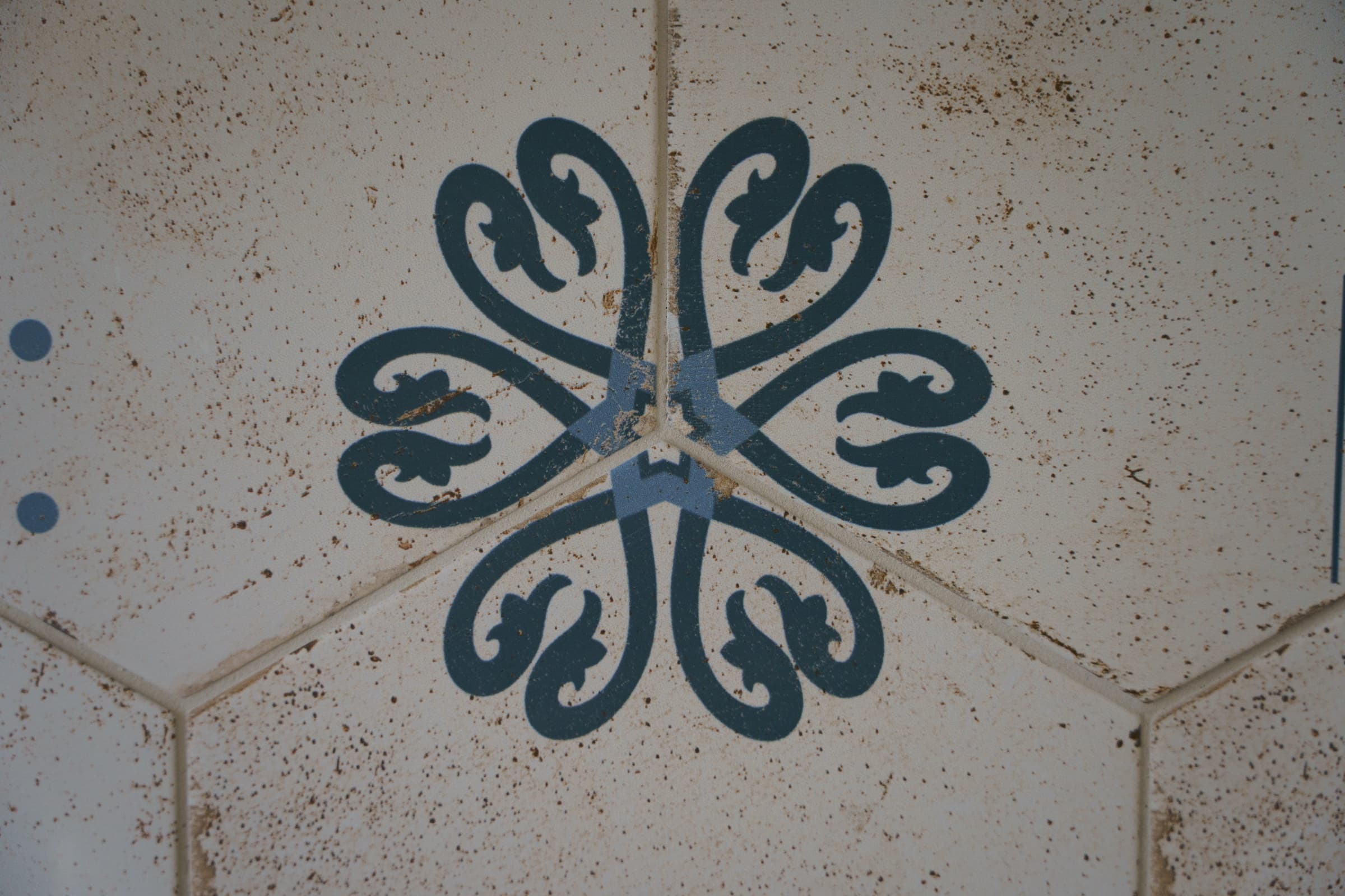 Carreaux de ciment hexagonaux d'origine, motif floral bleu-gris sur fond crème