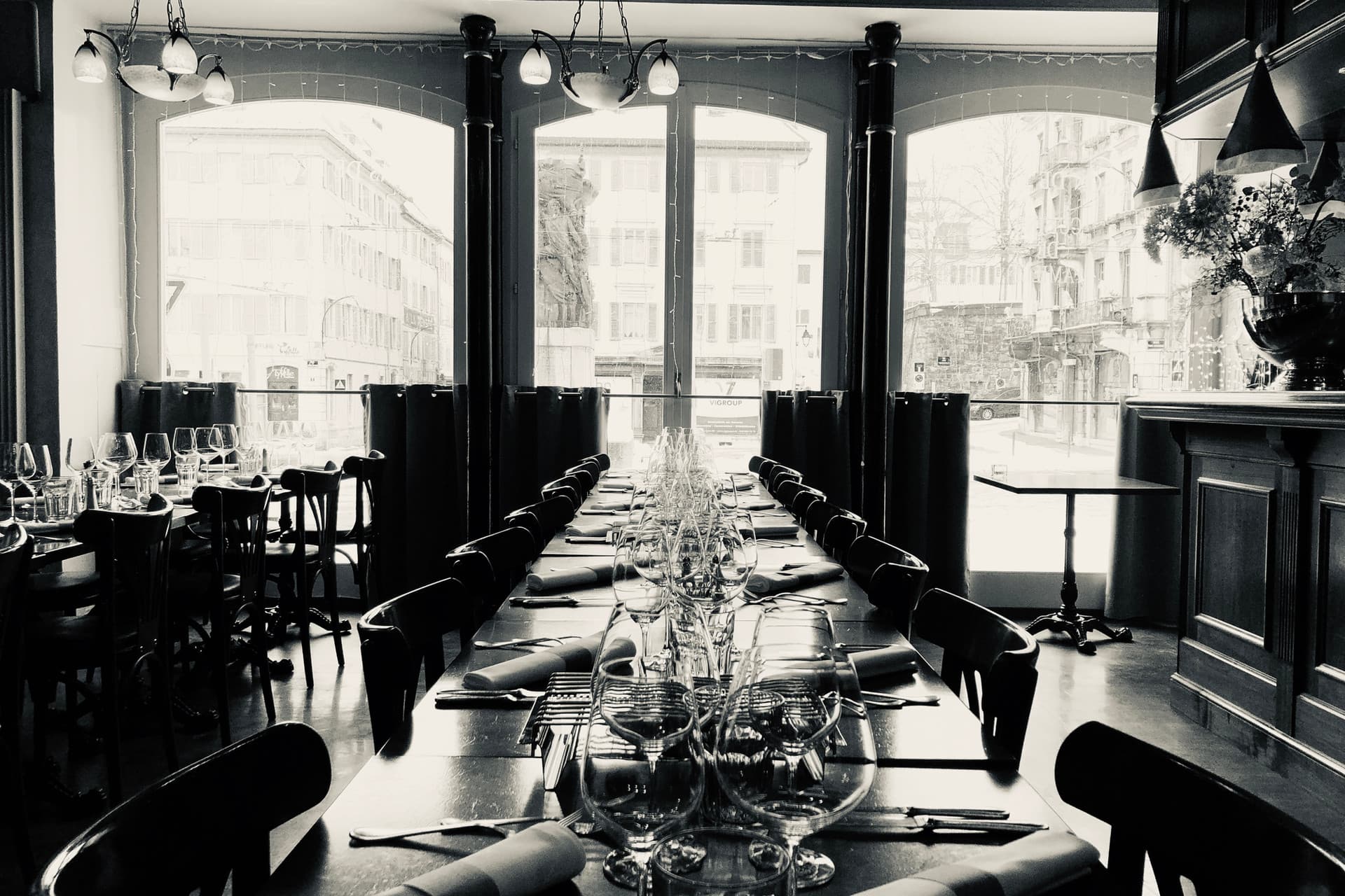 Salle de la Brasserie Hôtel de Ville à La Chaux-de-Fonds : banquettes rouges, miroirs et lustres dans un décor Belle Époque