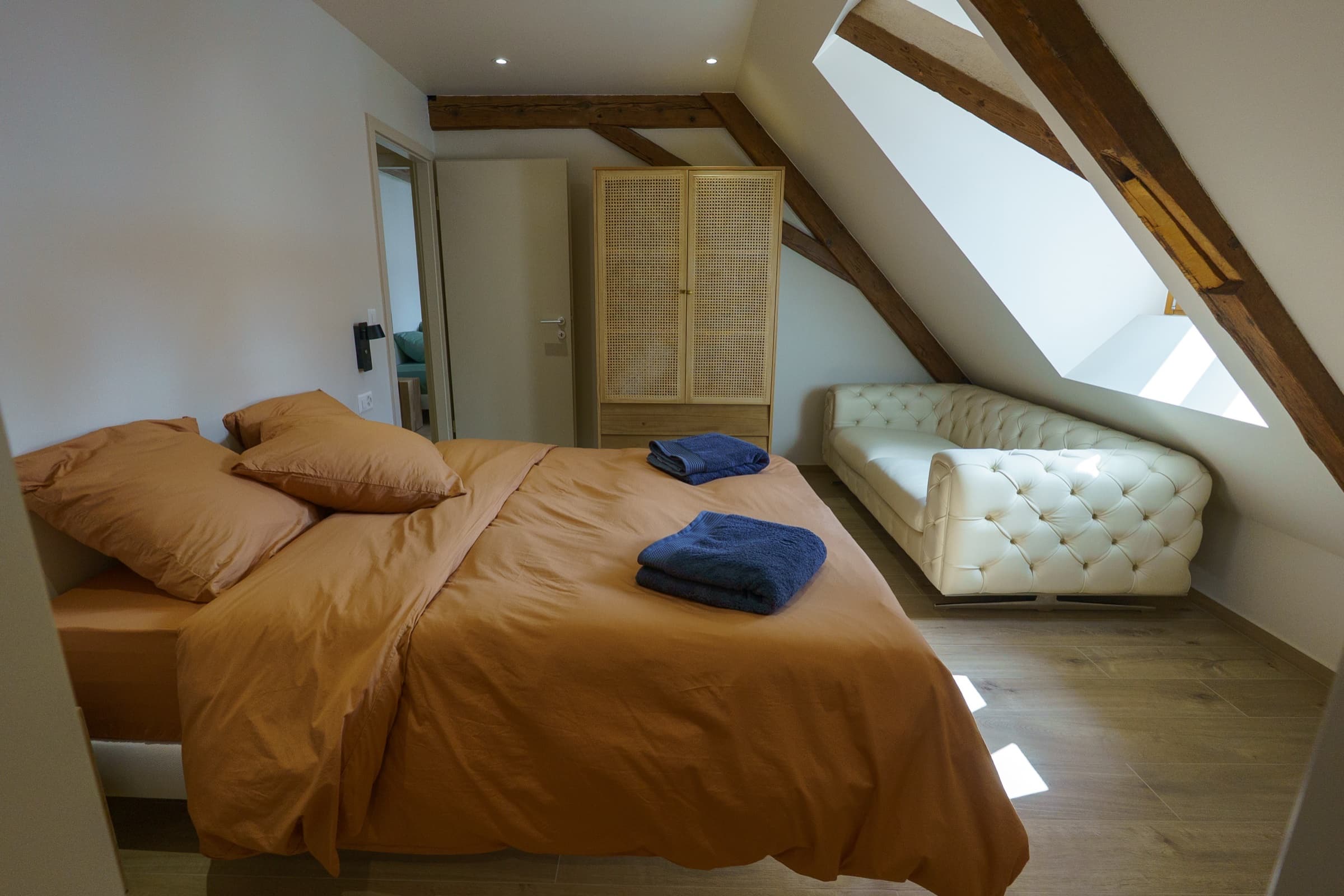 Literie ambre et fauteuil Chesterfield blanc — Suite Ambre du Rooftop, pierre Ceppo brun