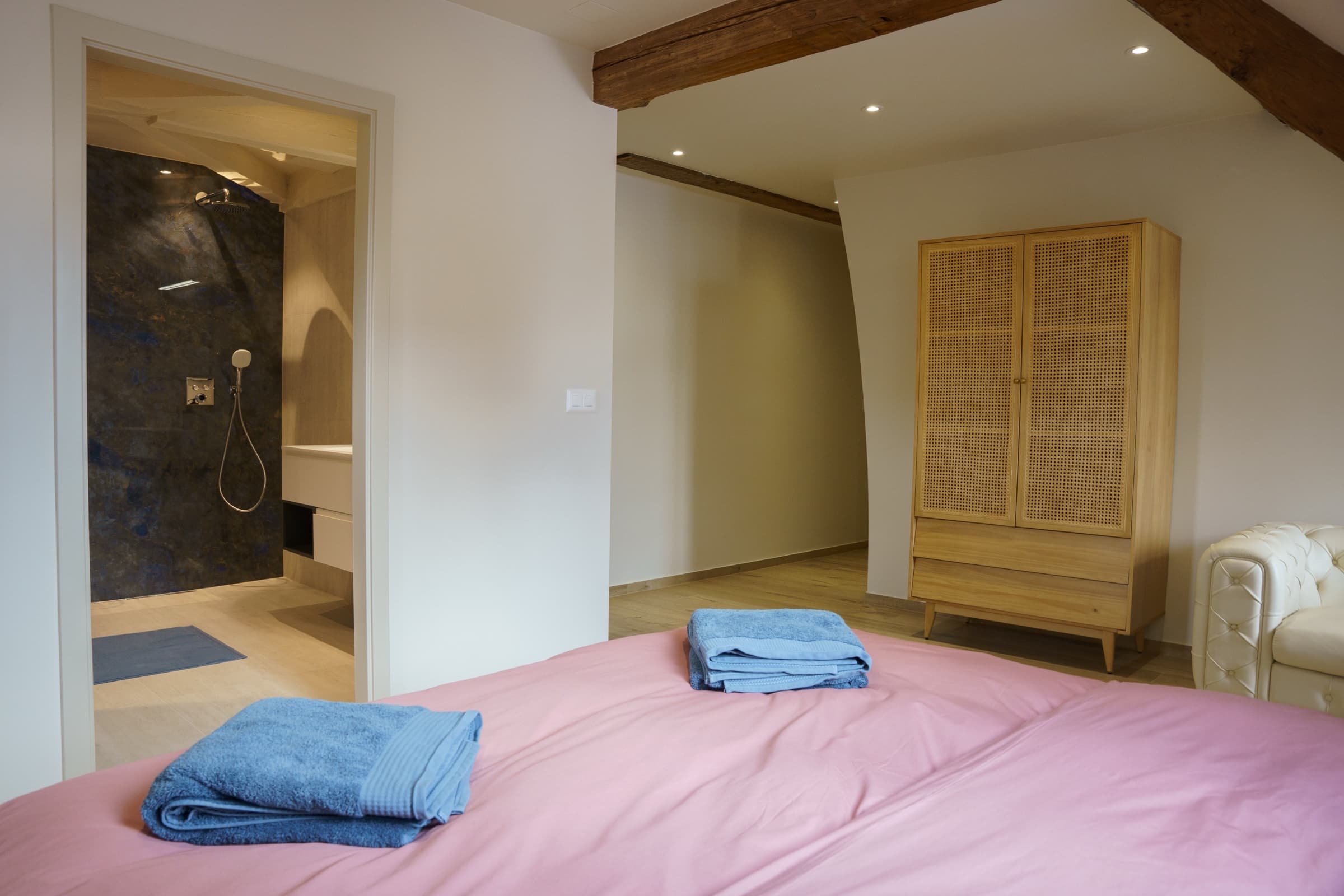 Suite Rose — détail literie rose poudré, appliques et tables de nuit