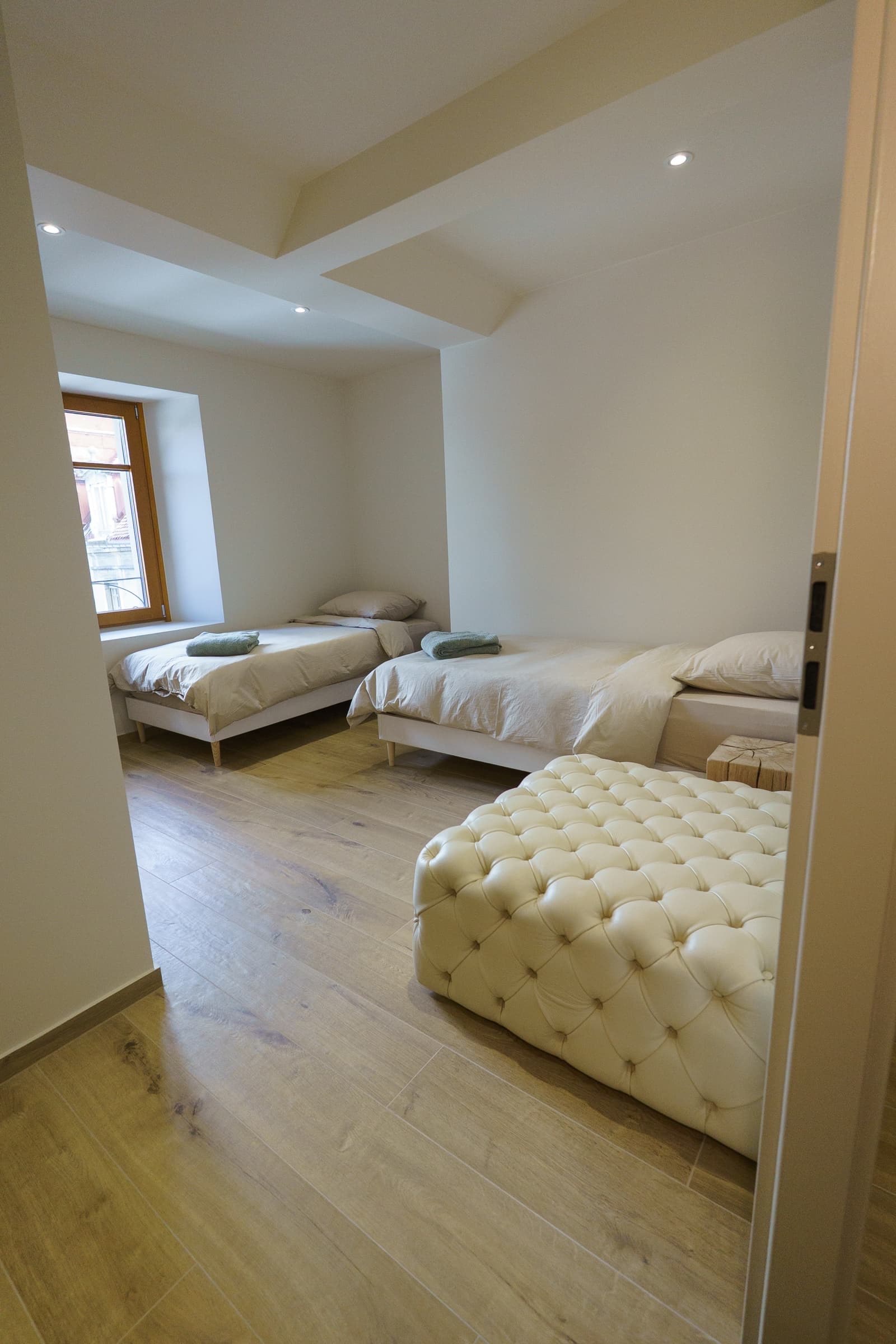 Suite Twin — salle de bain privée en pierre beige, douche italienne